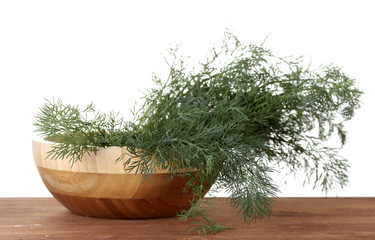 Dill in a wooden bowl on wooden