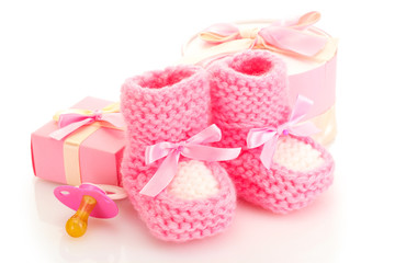 pink baby boots, pacifier, gifts and flower isolated on white