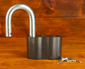 old padlock with keys on wooden background close-up