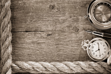 ship ropes and compass with pen on wood