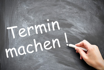 Termin machen wird auf eine Tafel geschrieben