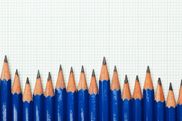 Row of pencils on a piece of graph paper