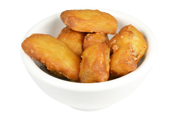 Baked kibbeling fish in a bowl on a white background.