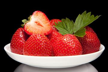 white saucer with red strawberr on a black background - 43013243