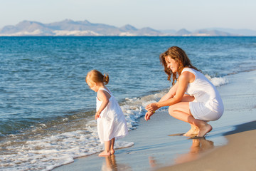 Mother with little daughter on the beach