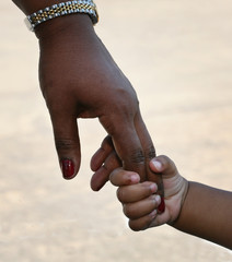 African-American family: child is holding mothers hand