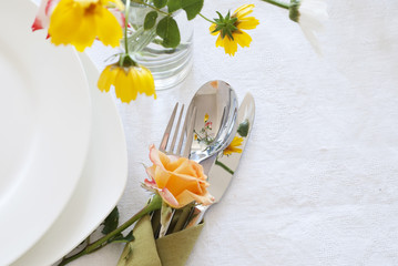 Table setting with plates, silverware and flowers