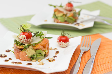 Avocado and salmon salad on square plate