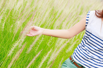 Woman's hand touching green grass