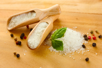 salt with fresh basil and and pepper on wooden table
