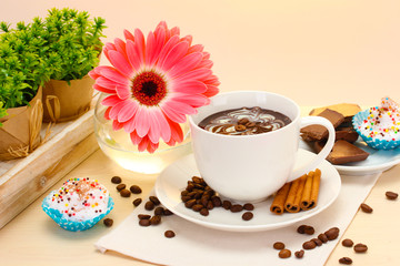 cup of coffee and gerbera  beans, cinnamon sticks