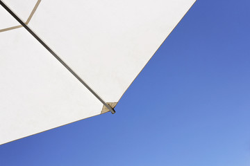 Weisser Sonnenschirm vor blauem Himmel