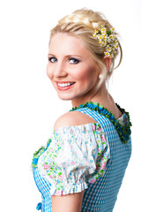 junge blonde Frau im Dirndl, über die Schulter schauend