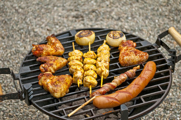 Grill mit Hühnchenflügel, Hühnchenspieß, Bratwurst, Speck