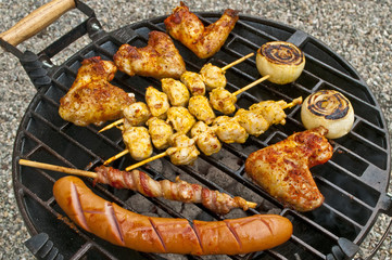 Grill mit Hühnchenflügel, Hühnchenspieß, Bratwurst, Speck
