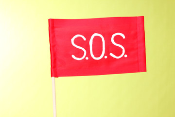 SOS signal written on red cloth on green background