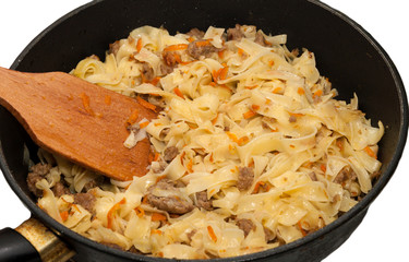 Frying pasta and carrots.
