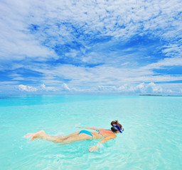 A woman with snorkeling mask diving