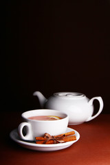 White cup and teapot on a brown background
