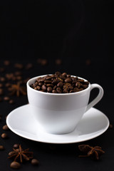 Coffee beans in white cup on black background