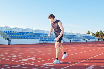 Fototapeta premium The young athlete is at the start. Against the background the tr