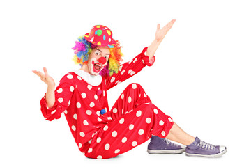 A portrait of a smiling happy clown sitting down