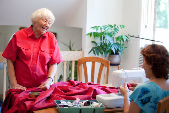 Volunteer helping senior with sewing project