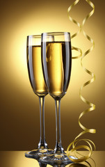glasses of champagne and streamer on yellow background
