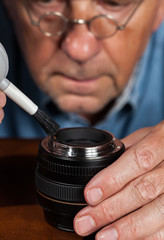 Senior craftsman cleaning lens