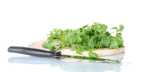 Coriander on a cutting board with knife isolated on white