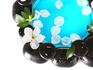 Composition of spa stones, blue water, petals and leaves