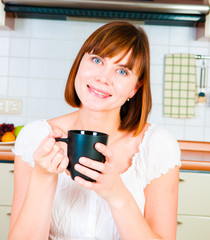  young  woman, enjoying a cup of coffee in her home.