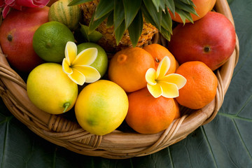 Basket of assorted tropical fruits with flowers