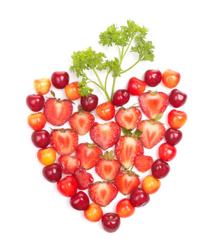 strawberries and cherries with greens in heart shape