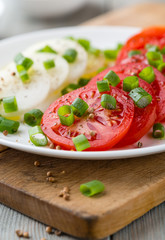 Tomatoes with chive and onion on a plate