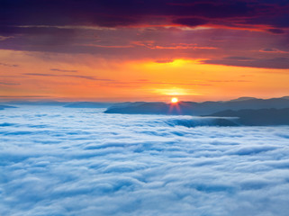 Fototapeta na wymiar Sunrise over the sea of fog in the mountains at the summer