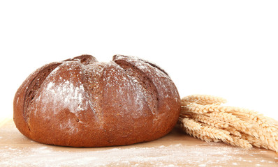 Homemade whole bread on wooden cutting board close-up