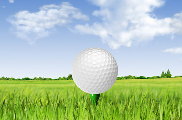 Golf ball on tee off over the green grass and clouded sky