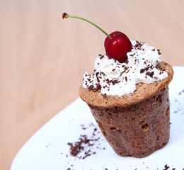 Delicious muffin with cream and a cherry
