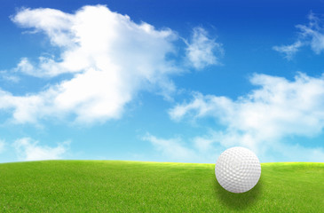 Close-up of golf ball with green grass and blue sky for web desi