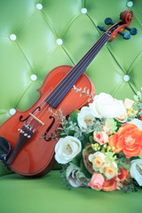 violin and bouquet flower on green leather background