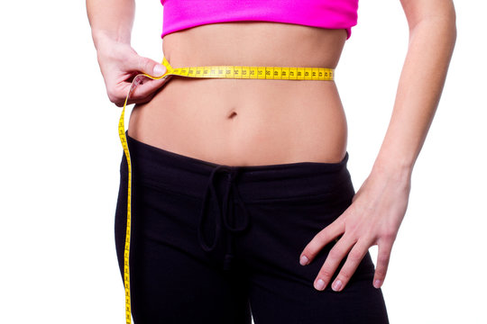 a slim girl measuring her waist - closeup, isolated