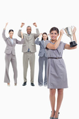 Woman holding up a cup with happy co-workers