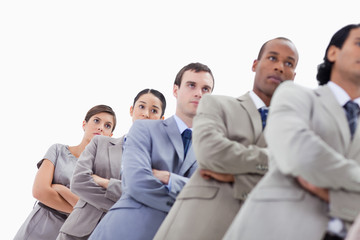 Low-angle shot of colleagues crossing their arms in a single lin