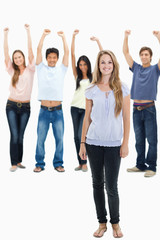 Woman smiling with people with their arms raised behind her