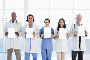 Medical team standing upright in front of the window while showi
