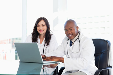 Two nurses working seriously while sitting at the desk in a well