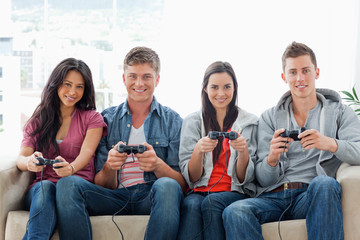 A group of friends play games while on the couch