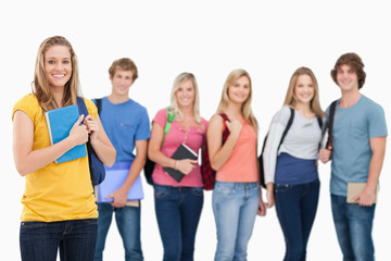 Obraz premium A group of college students standing as one girl stands in front