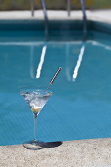 Aromatic gin tonic and mojito cocktails on swiming pool backgrou
